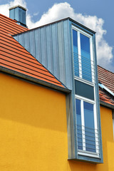 Dachgauben in Stehfalz-Zinkblechverkleidung am Ziegeldach eines Wohngebäudes Regenrinne und Regenfallrohr