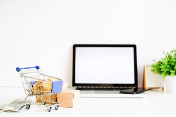 Shopping online concept, Money on Cart with box on office table.