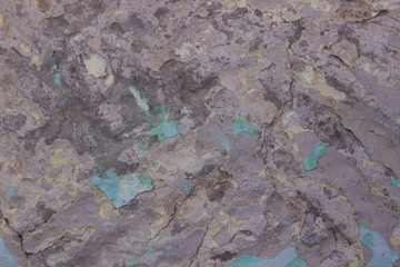 concrete old wall painted with blue paint with pastel yellow patches and cracks. Street background