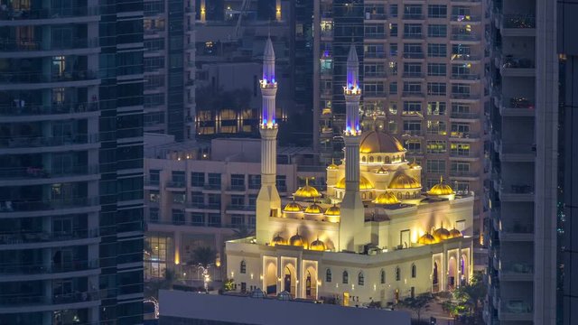 Al Raheem mosque between skyscrapers day to night timelapse on the marina walk in Dubai Marina, Dubai, UAE.