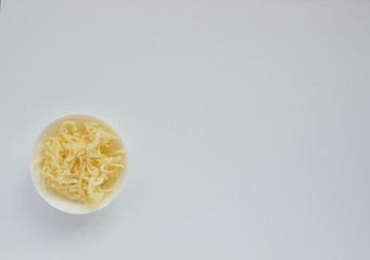 Dried squid shavings in a white Cup close-up on a light background © Людмила Ильина