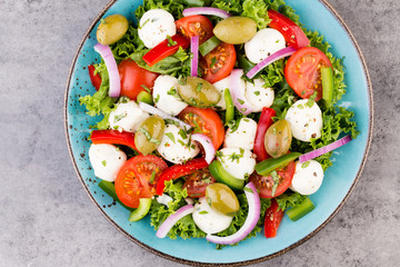 Vegetable salad with cheese mozzarella, tomatoes, basilikum and spice.