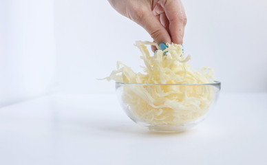 Female hand takes the chips dried squid in glass cup of close-up on white background
