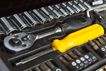 Fototapeta premium black metal tool box, yellow screwdriver and replaceable nozzles