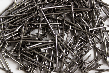metal nails scattered on a white background, close-up