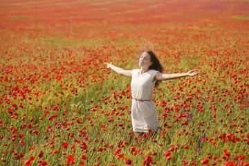 Naklejka na ściany i meble Beautiful woman in poppy field