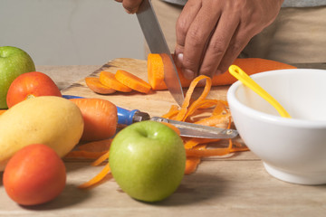peel and slice carrot on wood table