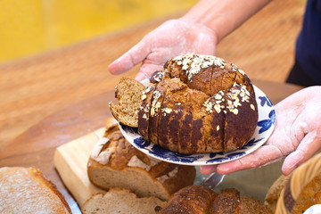 Various kinds of delicious brown breads are ready to be served to customers in bakery shop.