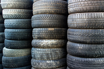 Pile of used car tires. Background with stacks of tires for recycling.