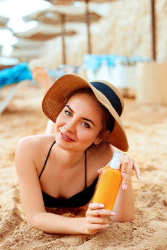  Sexy Young Woman in Bikini  Holding  Bottles of Sunscreen in Her Hands. Skincare. A Female  Applying Sun Cream Creme.Sun protection