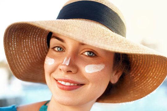 Woman smile applying sun cream  on face. Skincare. Body Sun protection. sunscreen. Bikini  woman smear  moisturizing lotion on skin.