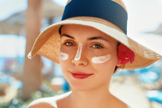 Facial Care. Female Applying Sun Cream and Smiling. Beauty Face.  Portrait Of Young Woman Smear  Moisturizing Lotion on Skin. SkinCare