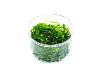 seaweed salad in plastic bowl on white background