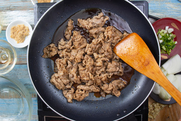 Cooking beef with by chef hands in pan