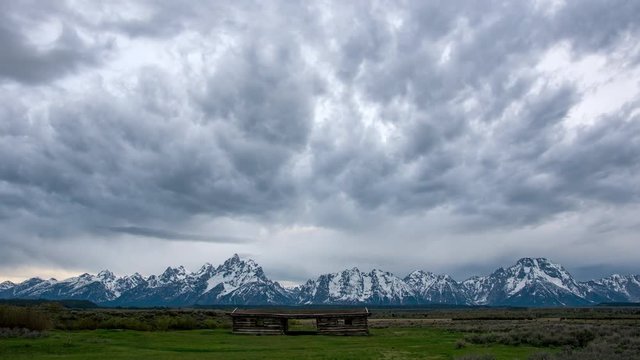 Time lapse overlooking the Grand Teton Mountains above the Cunningham Cabin in the evening on a cloudy day.