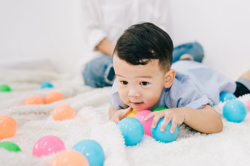 Family Concept - Adorable Asian Chubby Boy Playing Plastic Ball in Living Room on Vacation