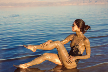 Fototapeta na wymiar A young woman enjoying the natural mineral mud
