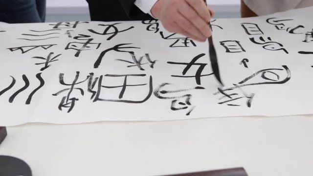 Chinese girl drawing chinese ieroglifs, national art, writing and drawing