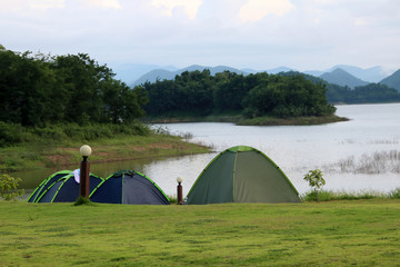 Campsite and tents on the lawn with beautiful green nature landscapes of dam water