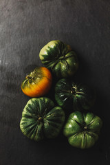 Green tomatoes in a graffiti background in a moody light
