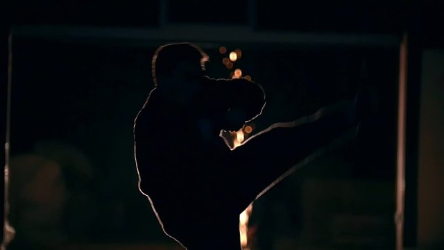 Man jumps and makes a reversal kick in the air with foot