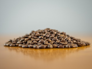 Mound of fresh whole coffee beans on a table