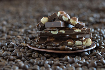 Grains of coffee and chocolate by closeup on a dish. End-view.