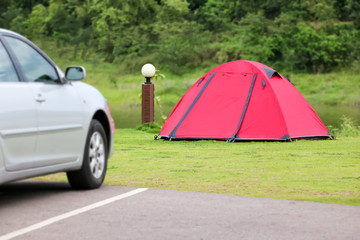 Weekend holiday in campsite and tents on the lawn and car park with beautiful green nature landscapes