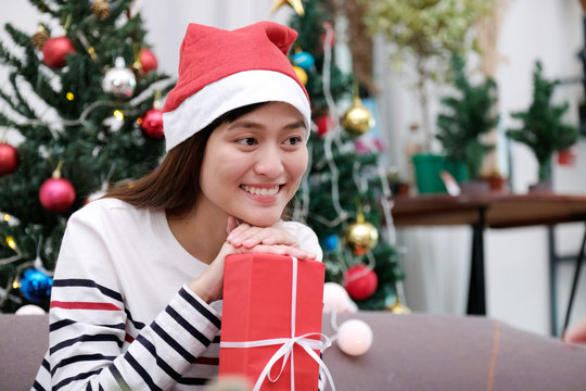 Young cute asian girl smiling and holding Christmas gift box at Christmas celebration party