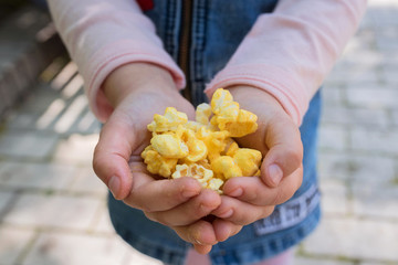 Popcorn in children's hands close up.