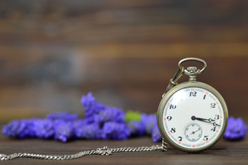 Fathers Day gift. Vintage pocket watch and spring flowers on wooden background