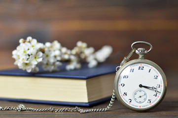 Fathers Day card. Vintage pocket watch, book and spring flowers on wooden background