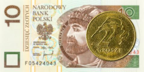 2 polish groszy coin against 10 polish zloty bank note