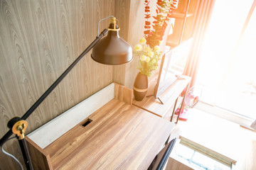 Working desk and chair with reading lamp in living room with shinning sunlight