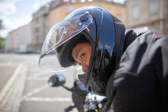 Woman with a black helmet on a motorbike