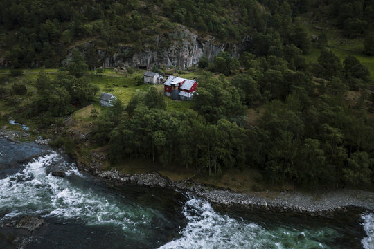Rural house in a forest by a river flowing through a Fjord in Norway