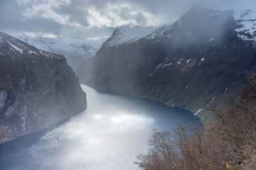 The rays of the sun hit the water of Geirangerfjord after a storm, Norway
