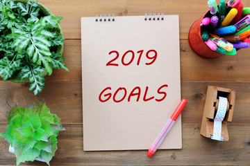 2019 goals on brown notebook paper at office desk background, banner sign, 2019 new year business strategy annual plan, success in business concept
