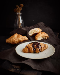 Croissant decorated with chocolate sauce.