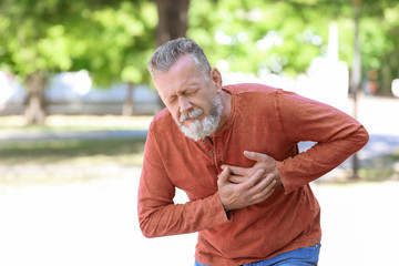Mature man having heart attack in park