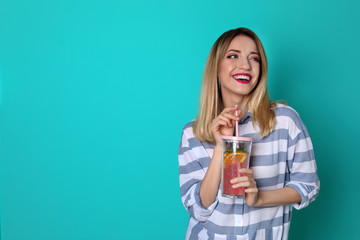 Young woman with tasty lemonade on color background. Natural detox drink