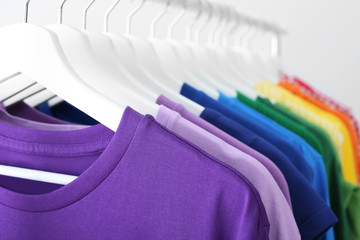 Obraz premium Rack with rainbow clothes on light background