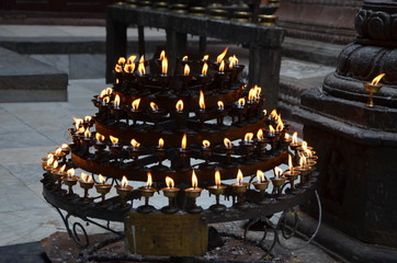 A multi-tier candlestick with candles in a Buddhist temple, Nepal
