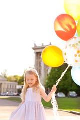 Obraz na płótnie Canvas Cute little girl with colorful balloons outdoors on sunny day