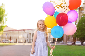 Cute little girl with colorful balloons outdoors on sunny day