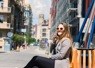 Obraz premium AN ATTRACTIVE BUSINESS WOMAN TALKS ON HER CELLPHONE