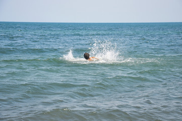 A drowning man. Sticking out of the ocean hands. Sinking human in the sea. Dangerous swimming in the blue water