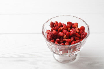Fresh strawberry fruit in a glass dish on a white background. Free space.
