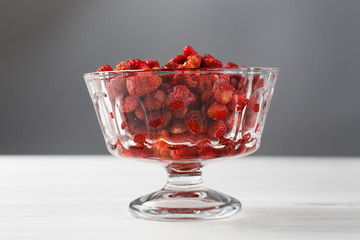 Fresh strawberry fruit in a glass dish on a white background.