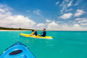 Family kayaking at tropical ocean